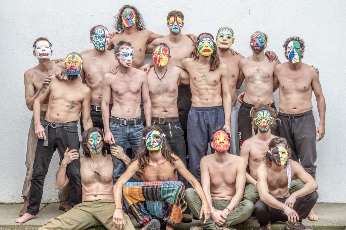 Eine Gruppe von Männern mit selbst gestalteten, bunt bemalten Masken
